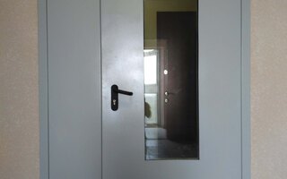 противопожарная дверь серого цвета со стеклопакетом и одним замком